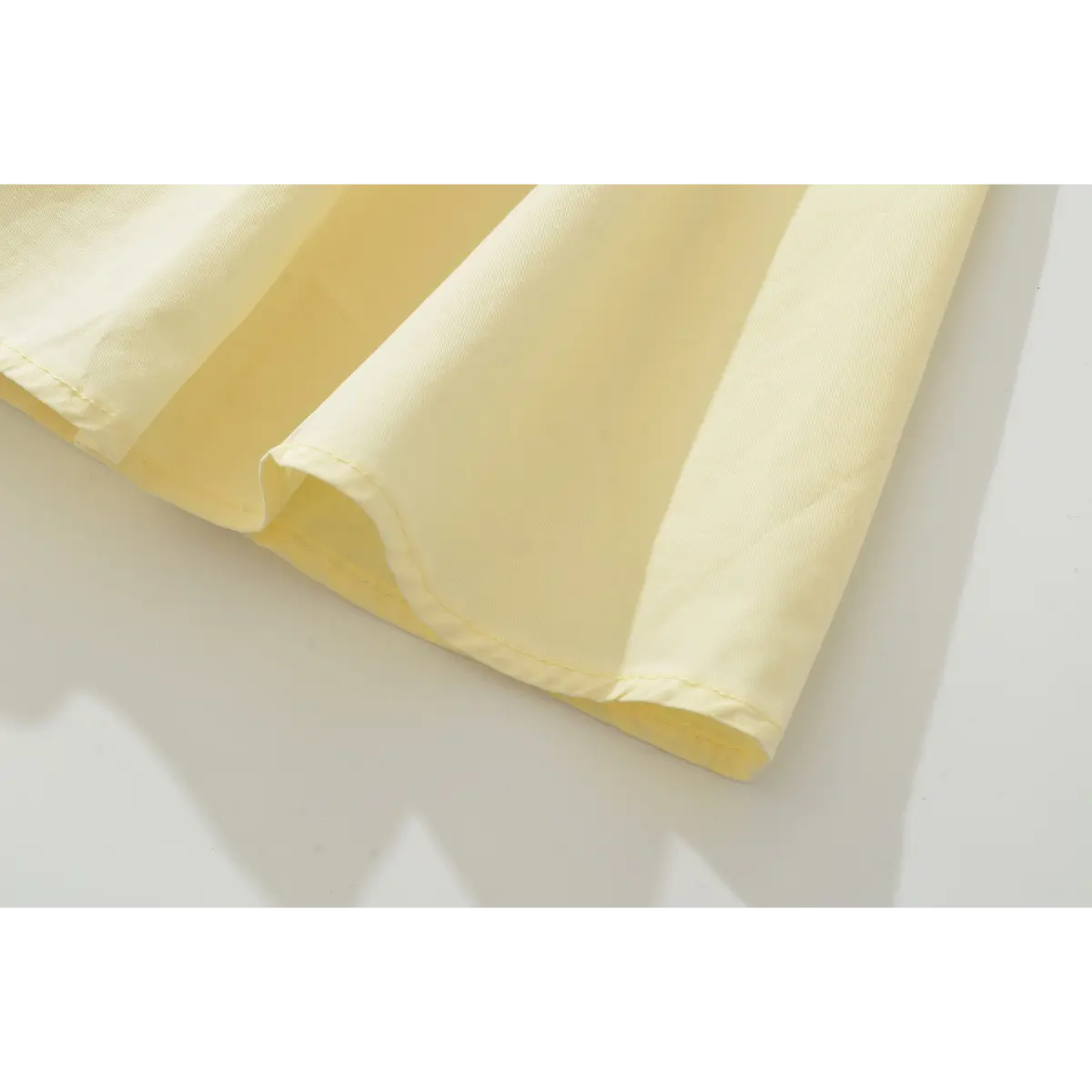 Close-up of the dress's hem, showcasing the neat double-stitched edge and smooth fabric finish.