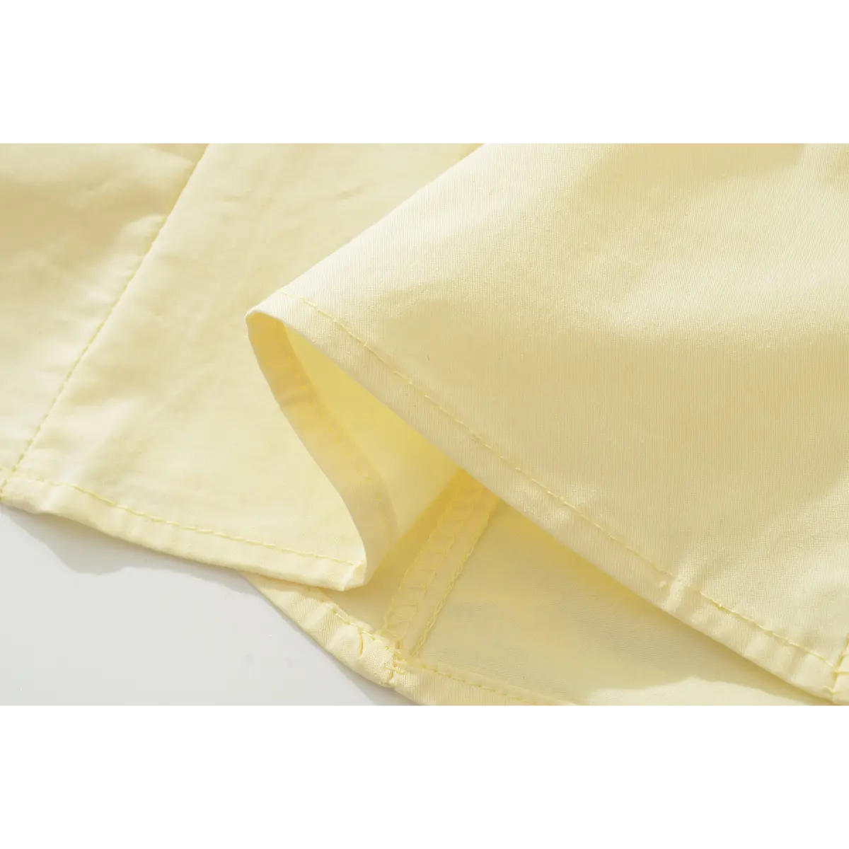 Close-up of the dress's hem, revealing the inner lining, seam construction, and folded edge.