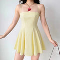 The pale yellow spaghetti strap dress styled on a model, highlighting its flattering silhouette, lightweight fabric, and how it complements everyday accessories.