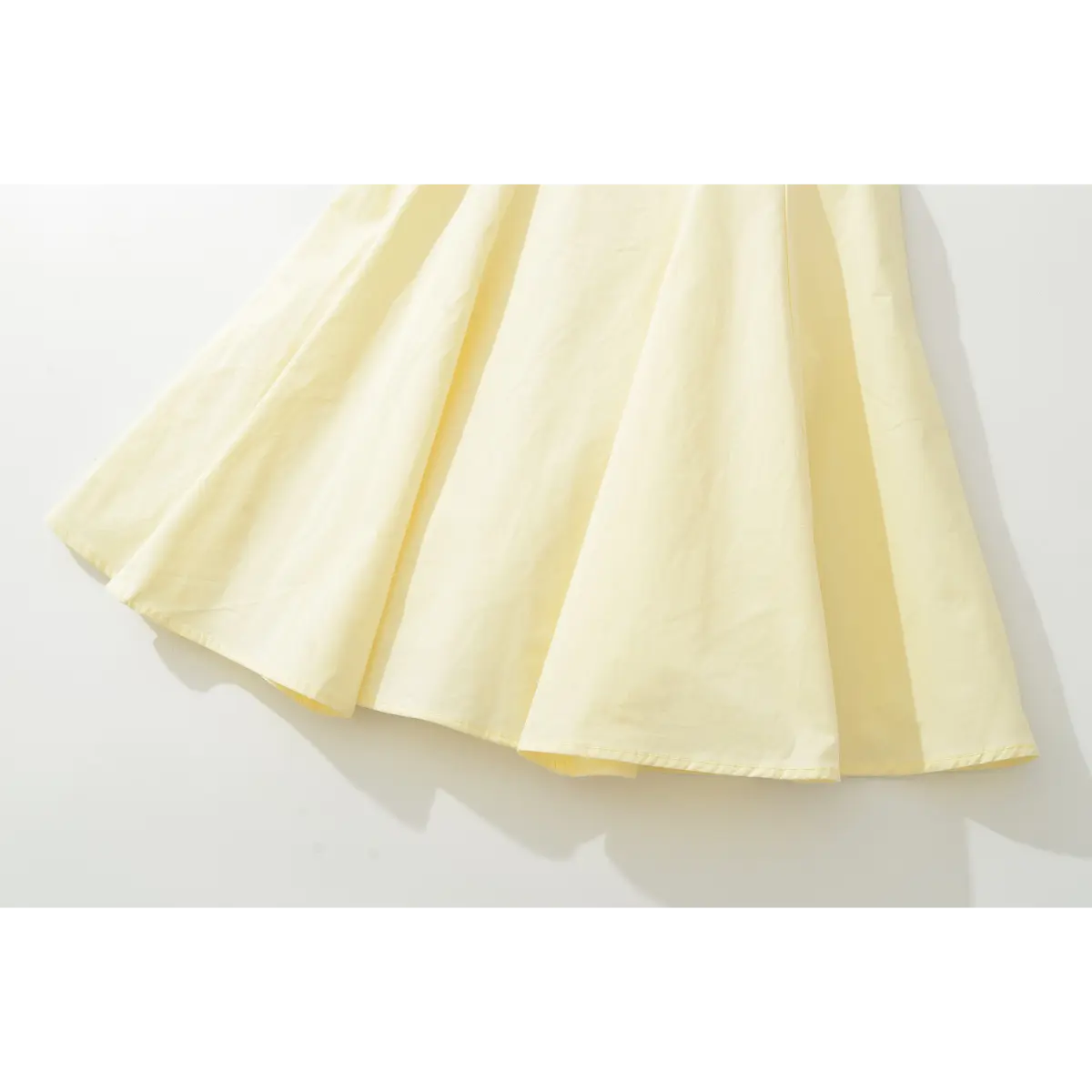 Close-up of the dress's flared A-line skirt, showing the fabric drape and gentle pleats.