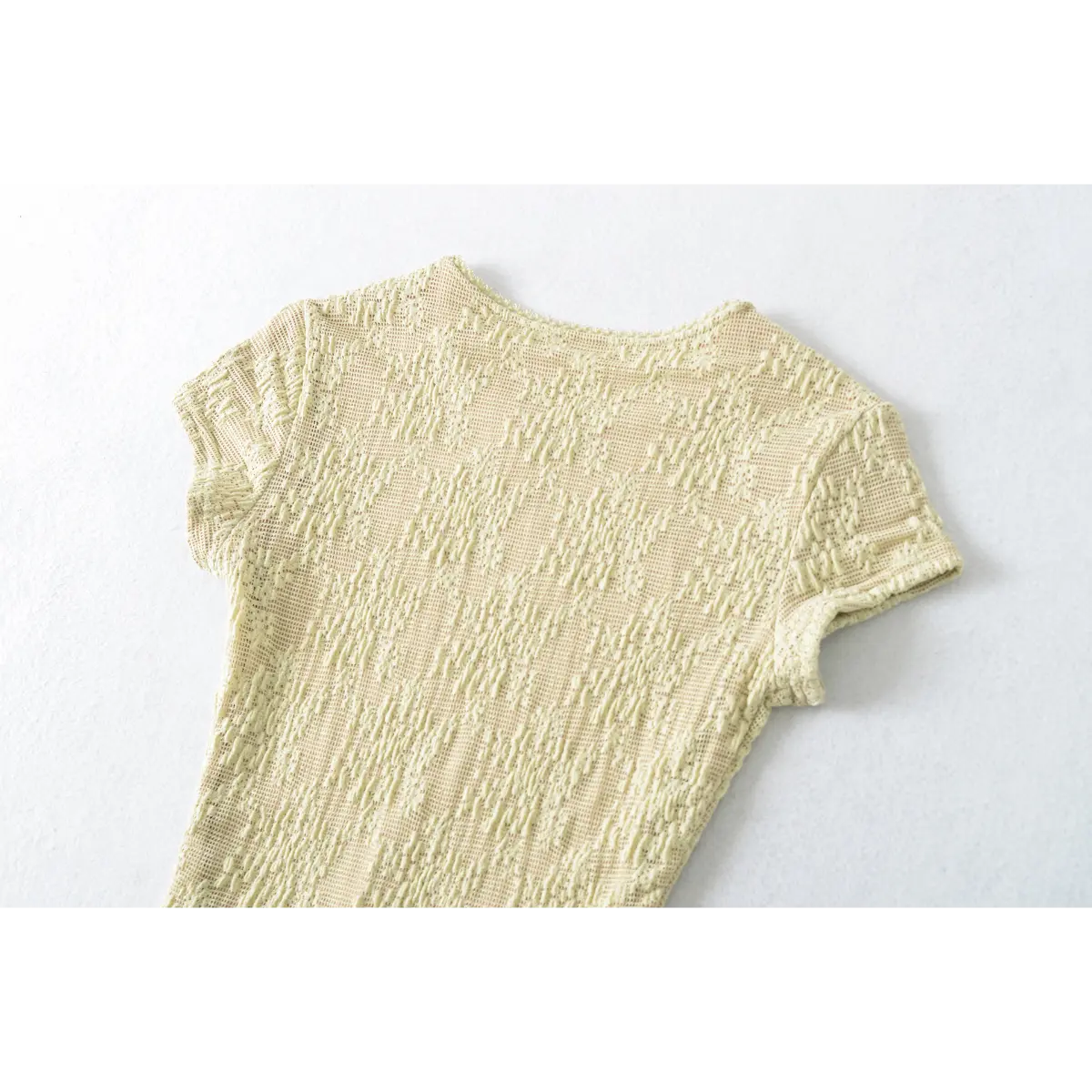 Back view of the pale yellow lace top, highlighting the seamless fit and crew neckline.