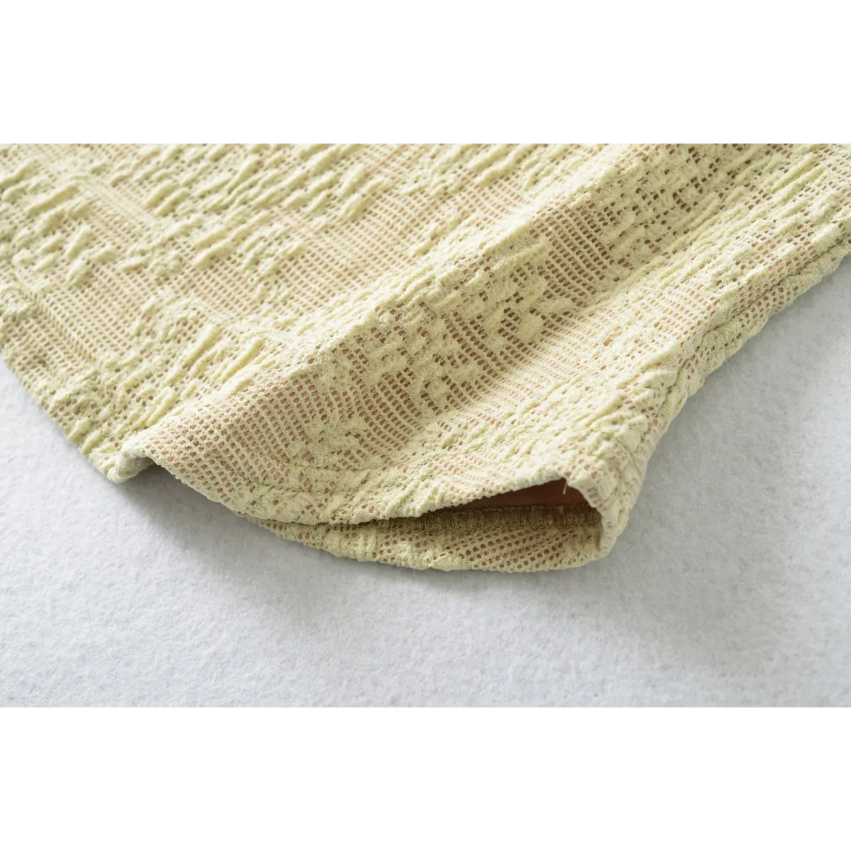 Close-up of the textured lace pattern, showing the openwork design and raised floral motifs.