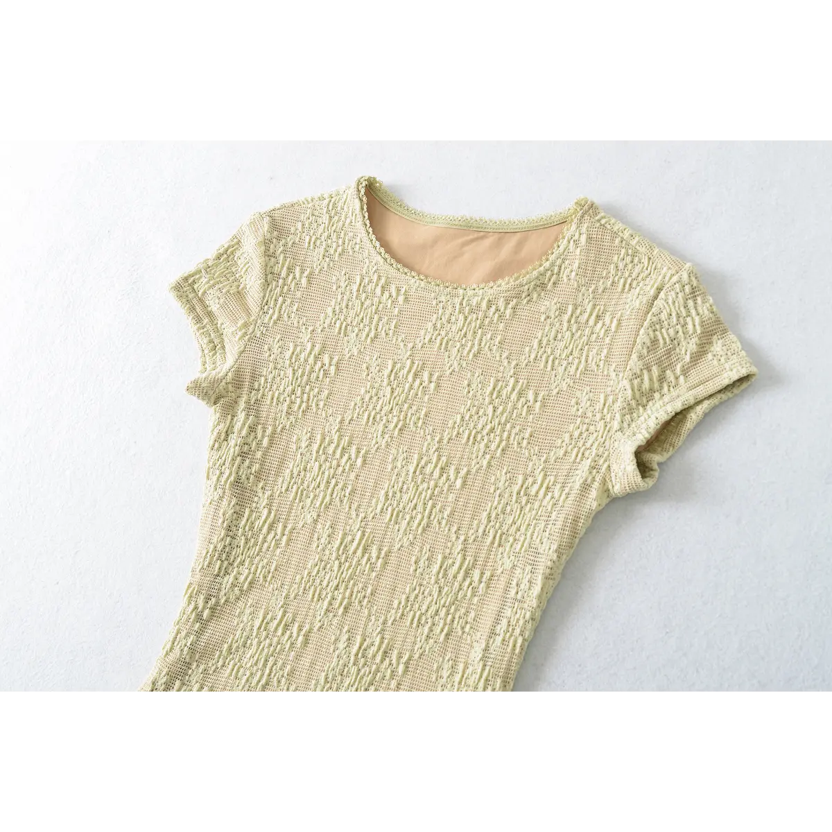 Full front shot of the pale yellow lace top, showing the crew neckline, short sleeves, and fitted silhouette.