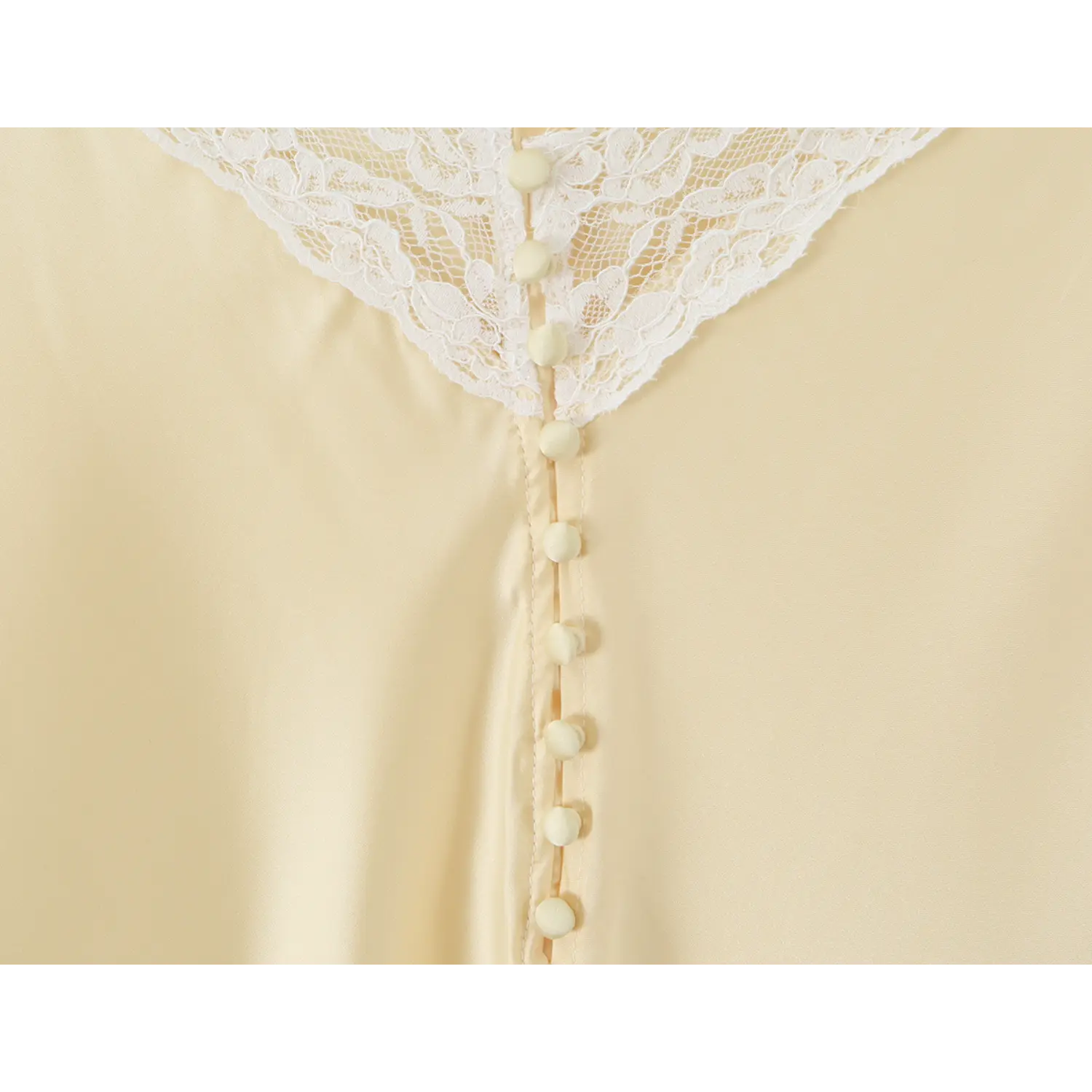 Macro close‑up of decorative back button placket with lace top