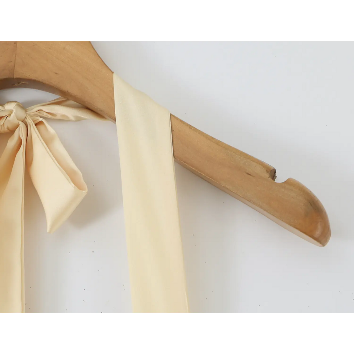 Close‑up of fabric halter neck tie knot on wooden hanger