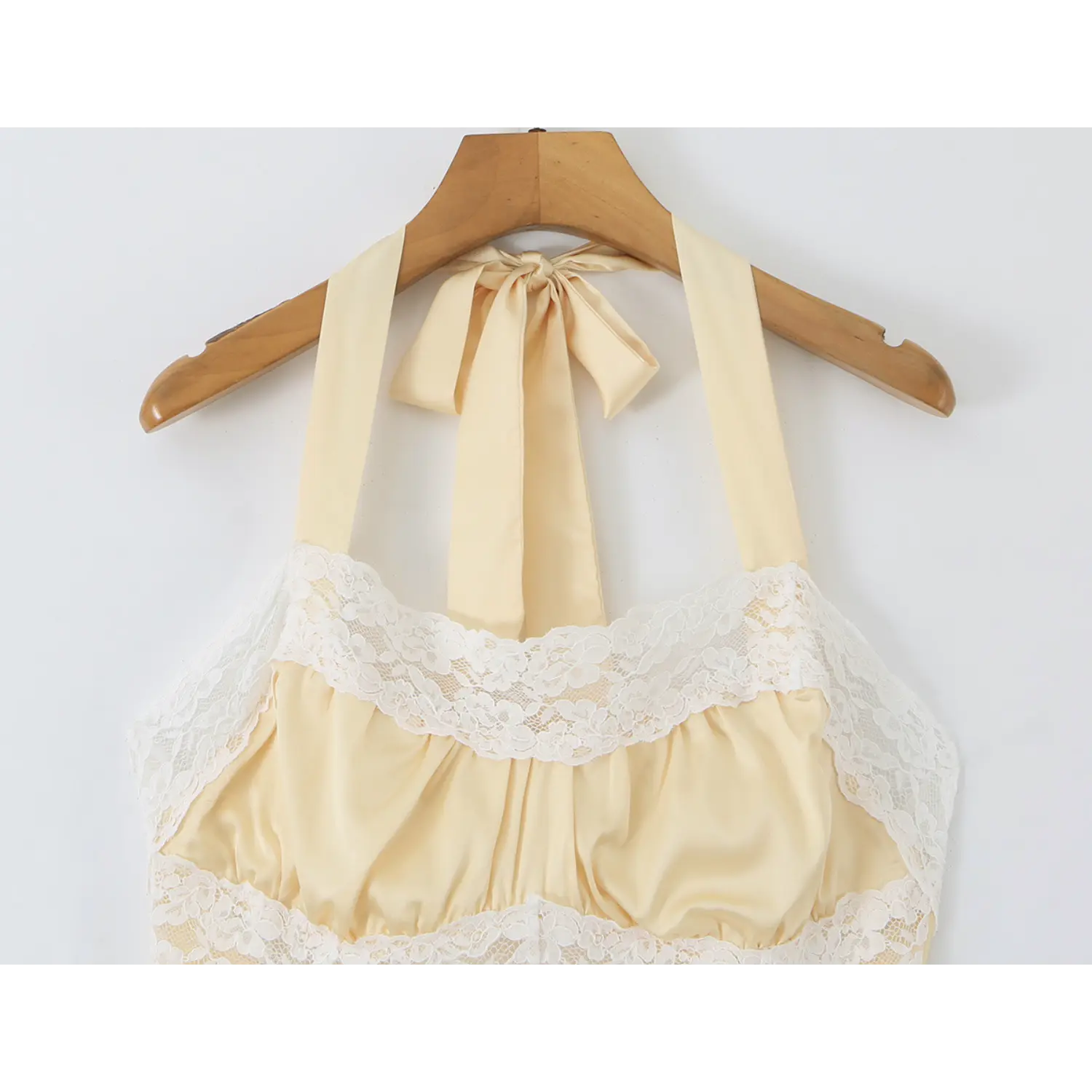 Close‑up of halter neck tie‑back and lace bust detail on wooden hanger