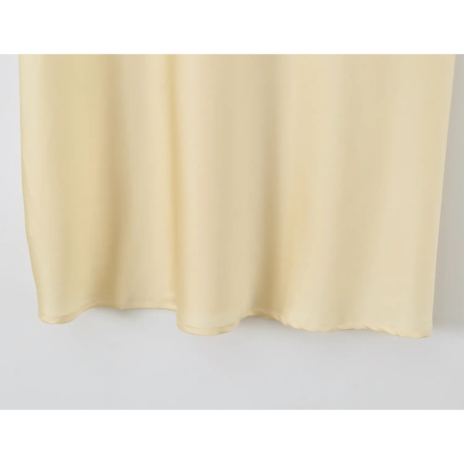 View of flowy finished hem of pale yellow satin maxi skirt