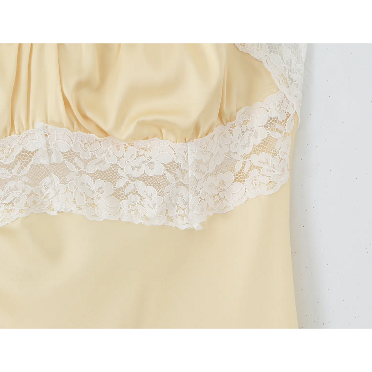 Partial close‑up of waist white lace panel and gathered bust detail