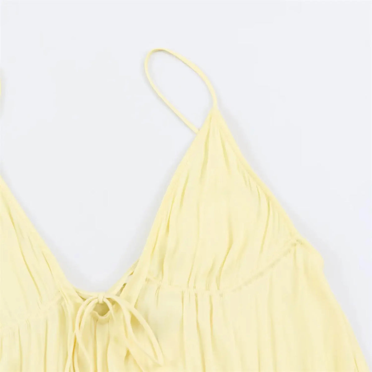 Close‑up of smocked elastic bodice and v‑neck tie