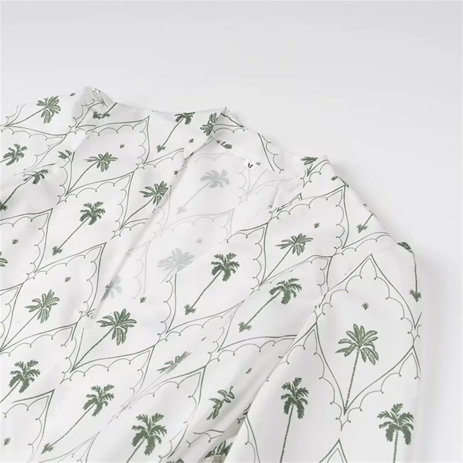 Close-up detail of v-neckline and palm tree fabric print
