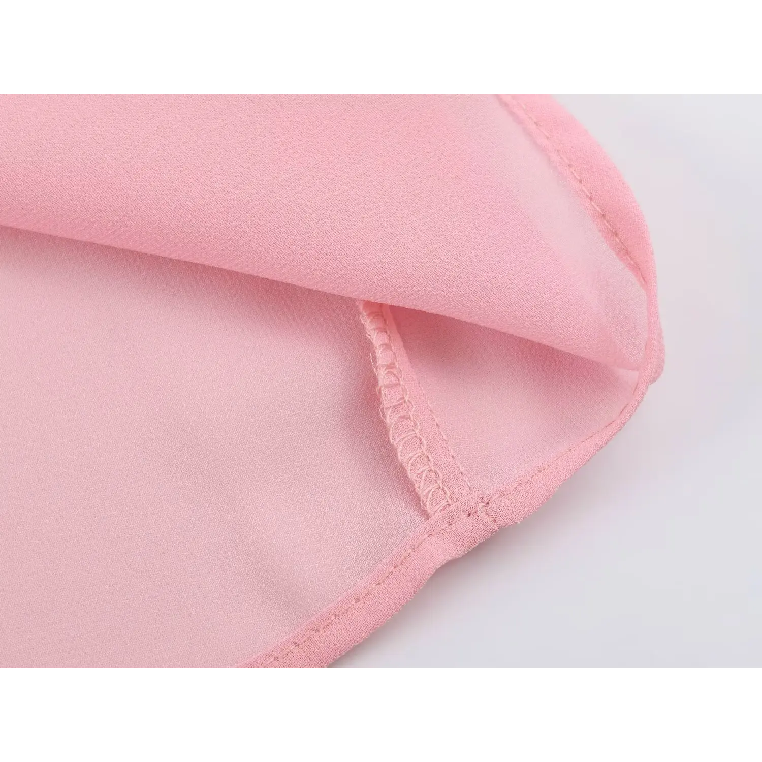 Folded hem shot showing outer chiffon and solid lining, overlock stitching construction