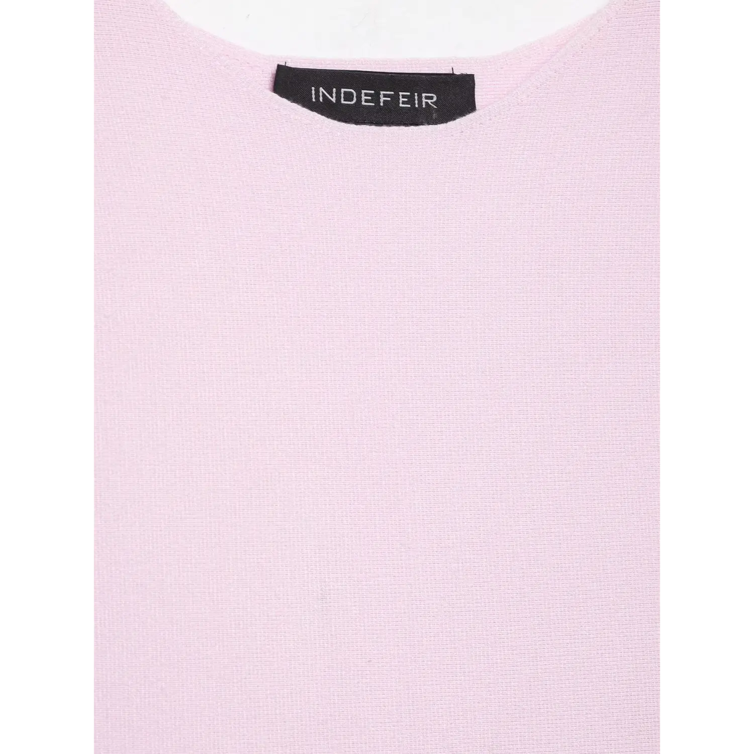 Close-up of inner label at crew neck on pastel pink fine rib knit peplum top