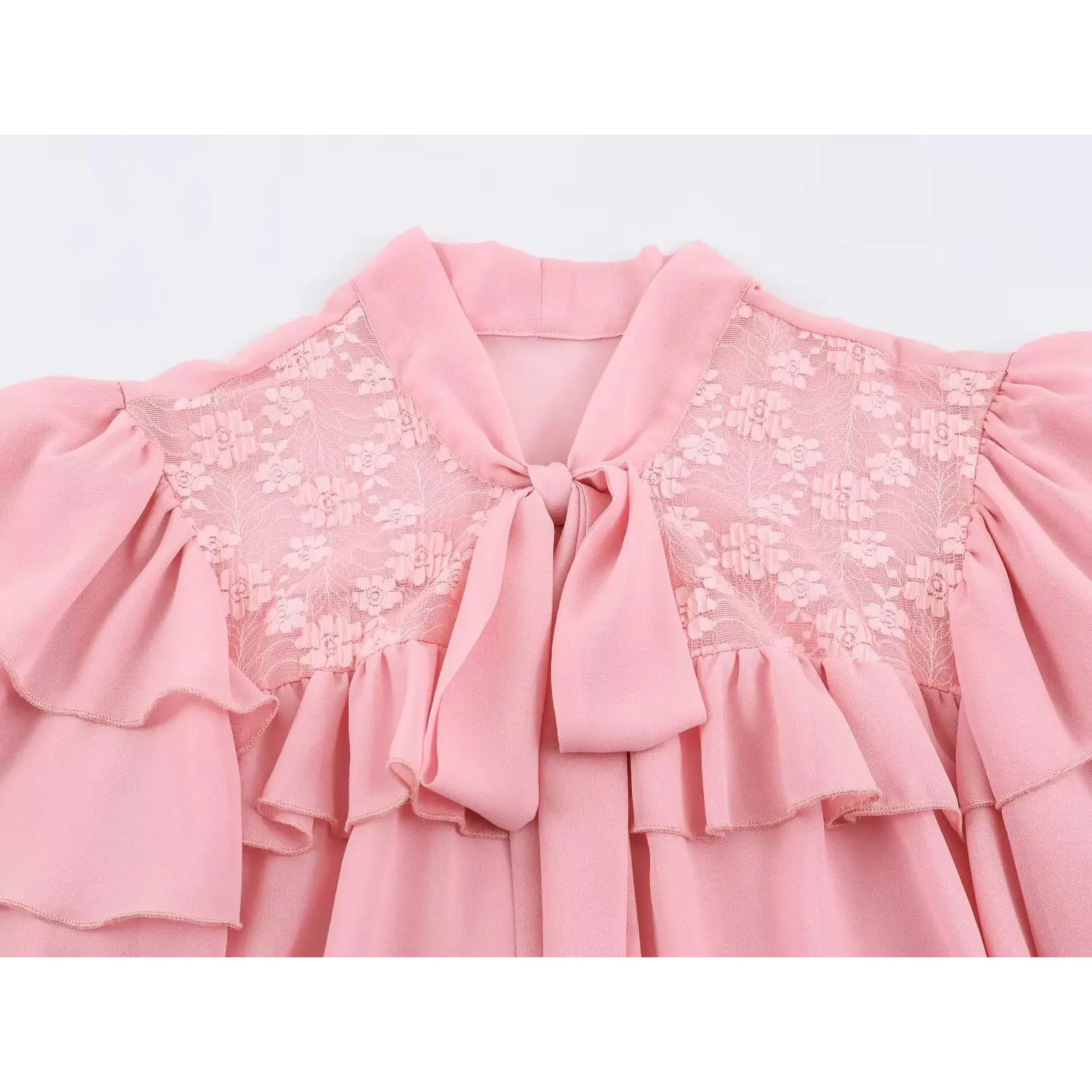 Closeup stand collar with hanging fabric bow, upper chest floral embroidered lace panel, front ruffle trim