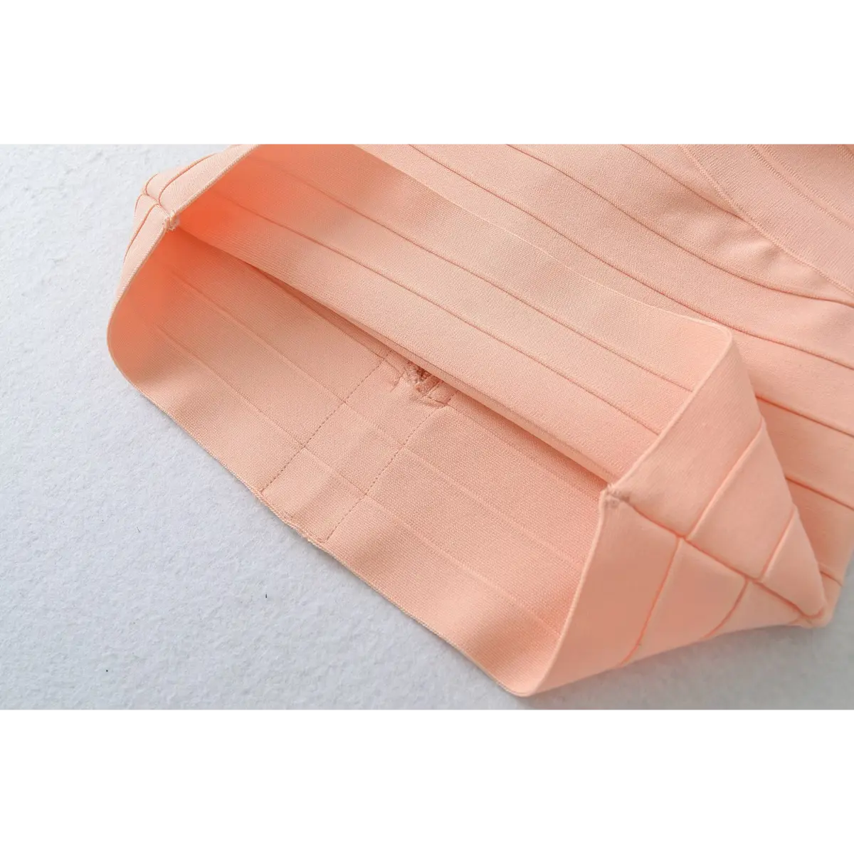 Close-up of the smooth lining and finished hem inside the peach bandage top.