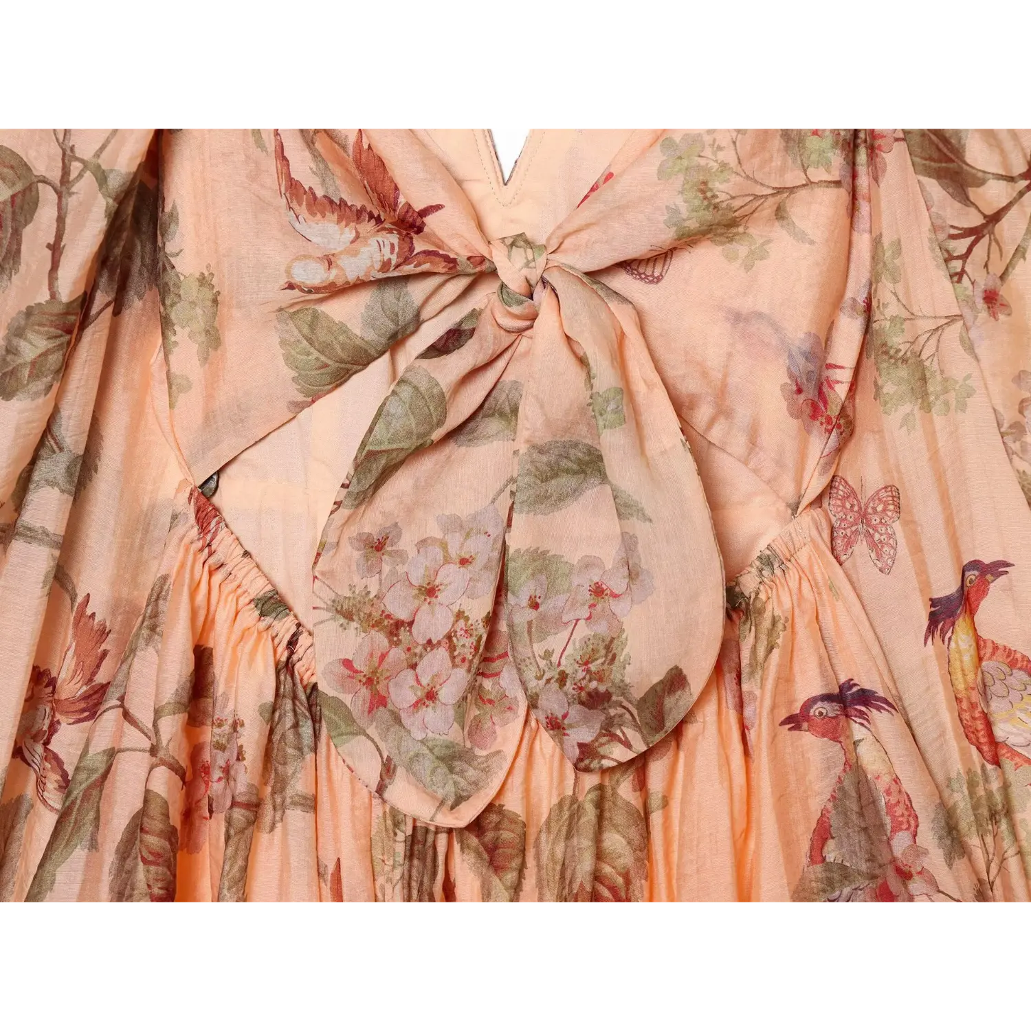 Close‑up of large fabric back tie bow, vintage bird floral butterfly print, elastic gathered waist detail on peach mini dress