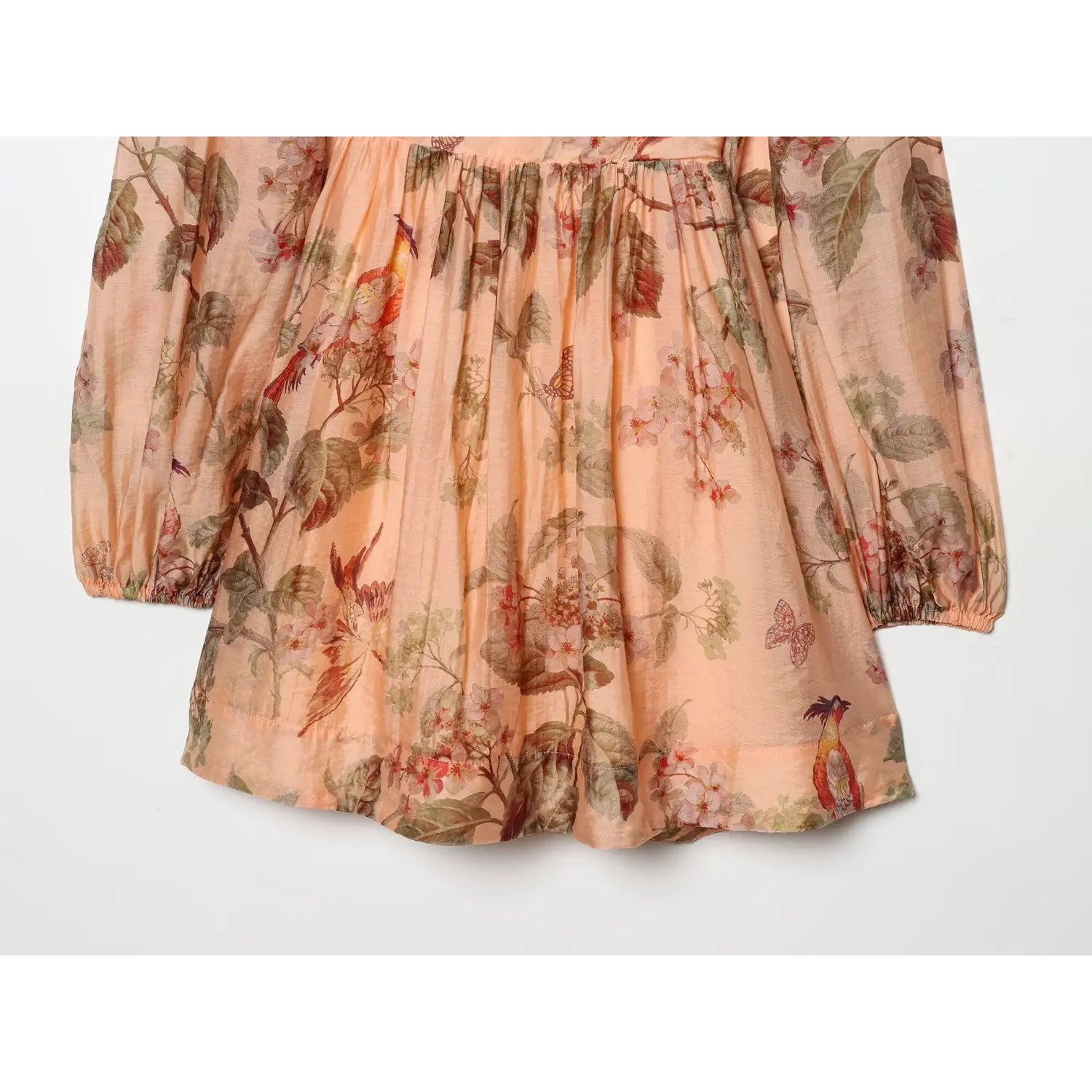 Flat‑lay close‑up of gathered babydoll skirt, flowy silhouette, vintage bird flower butterfly print