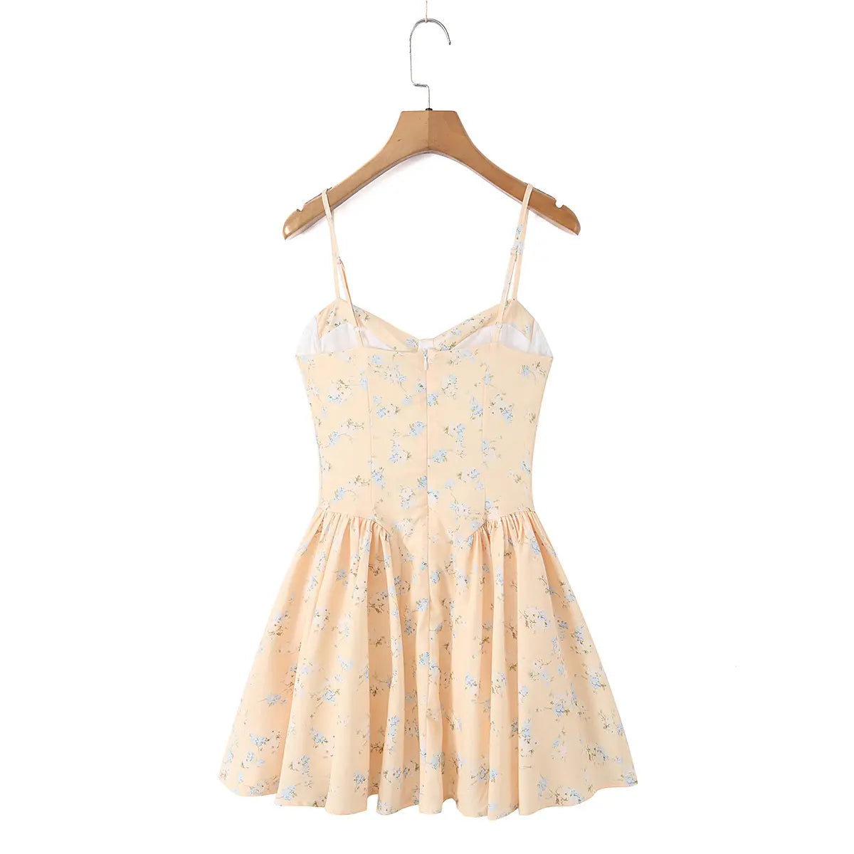  Back view of a peach floral print spaghetti strap dress hanging on a wooden hanger.