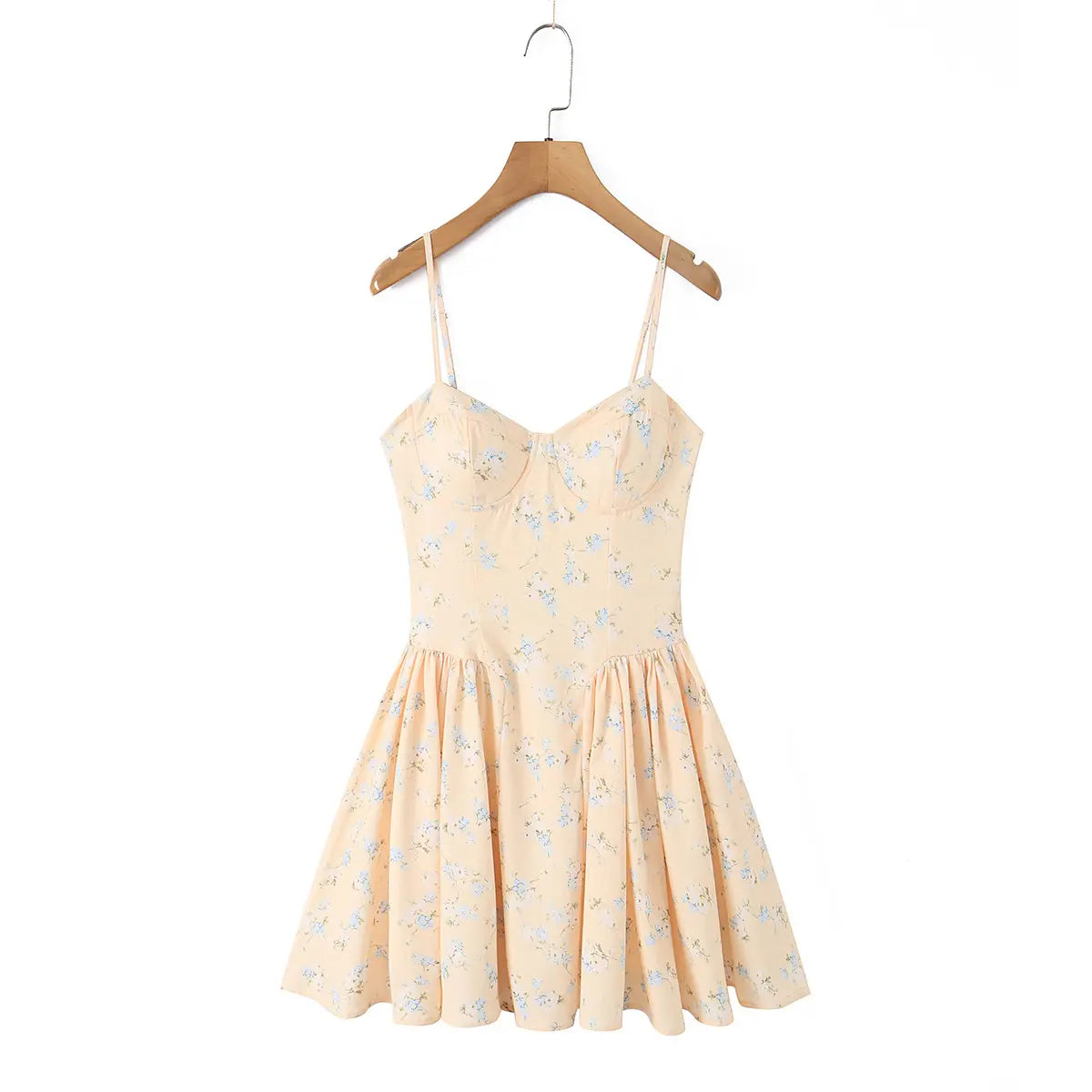 Front view of a peach floral print spaghetti strap dress hanging on a wooden hanger.
