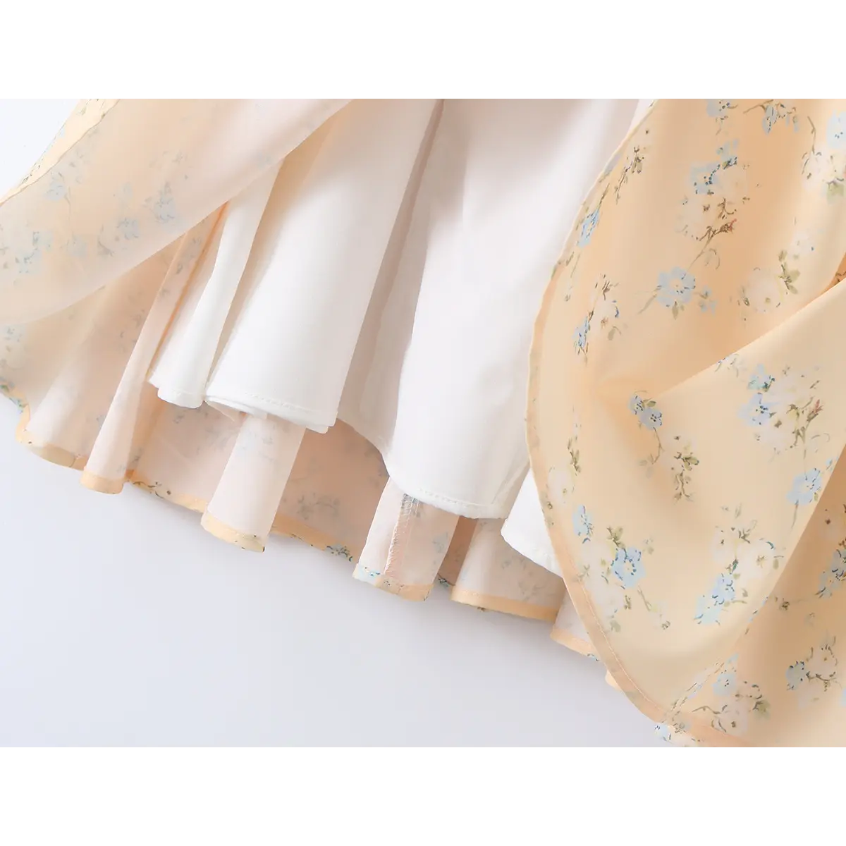 Close-up of the lining and skirt layers on a peach floral print corset-style dress.