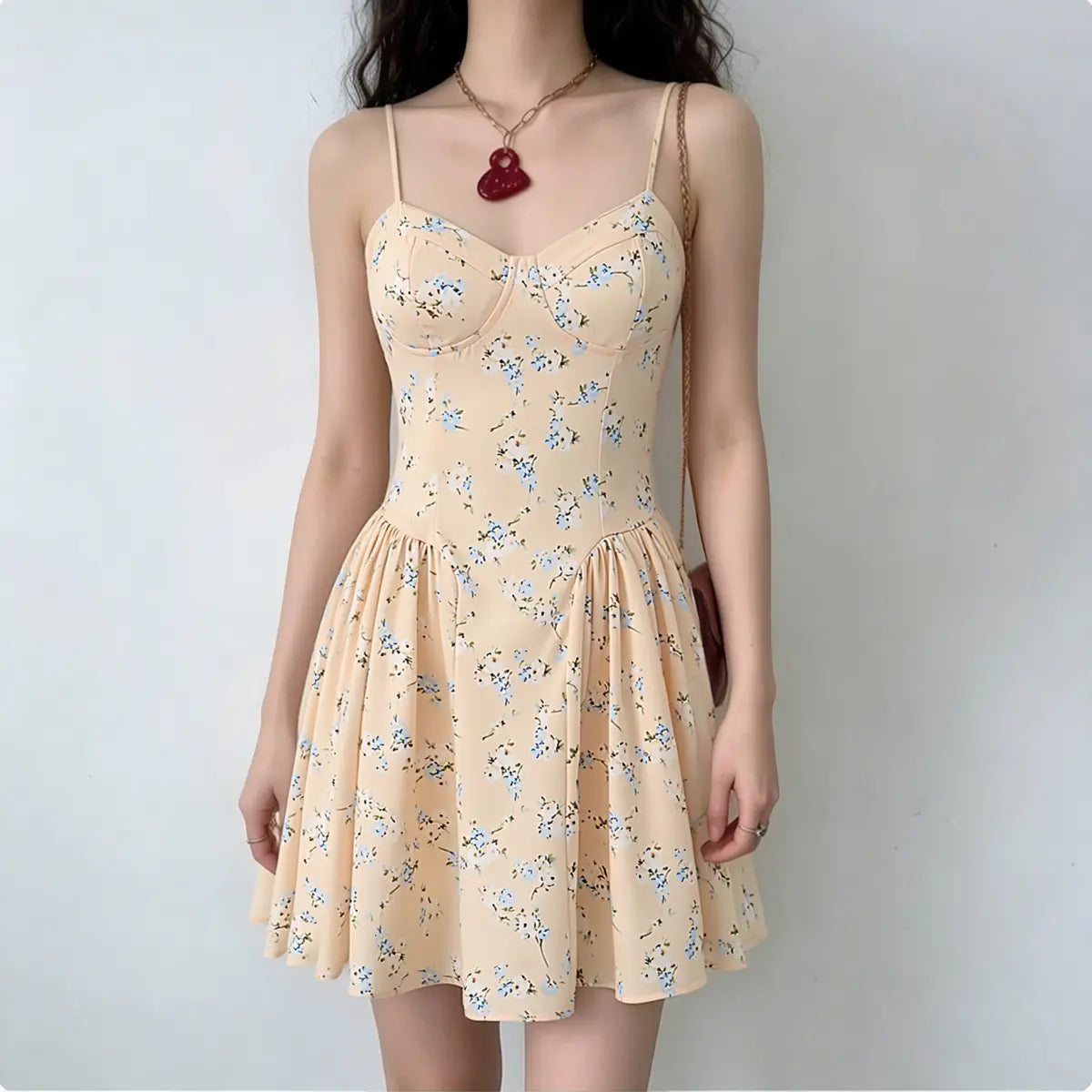 Full-body shot of a woman wearing a peach floral print spaghetti strap dress with a corset-style bodice.