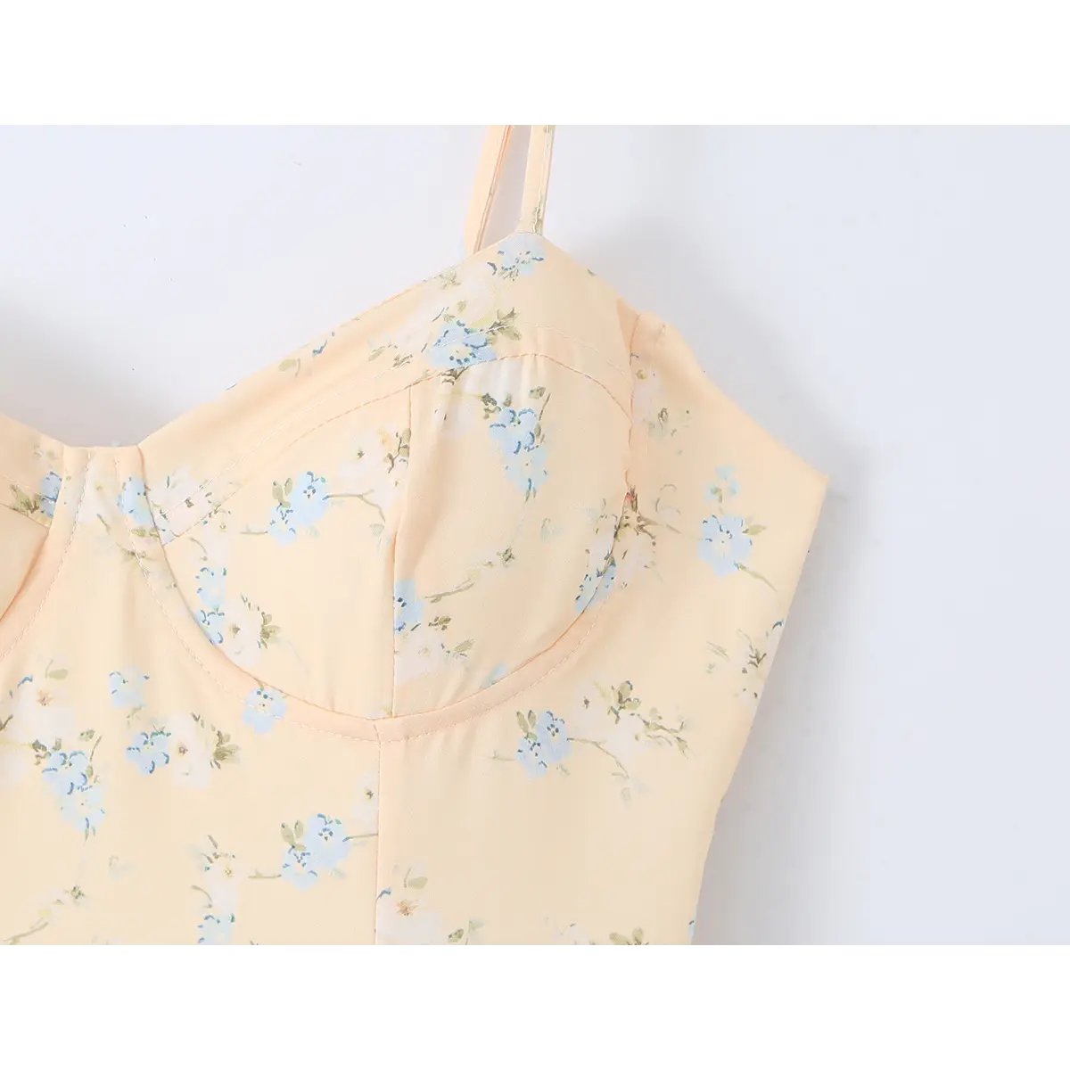  Close-up of the corset-style bust detailing on a peach floral print dress.