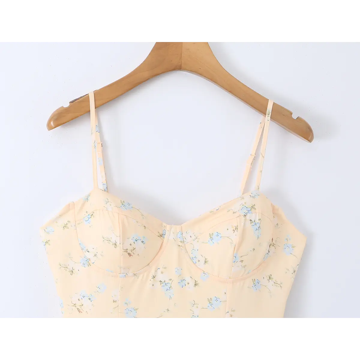 Close-up of the spaghetti straps and sweetheart neckline on a peach floral print dress.