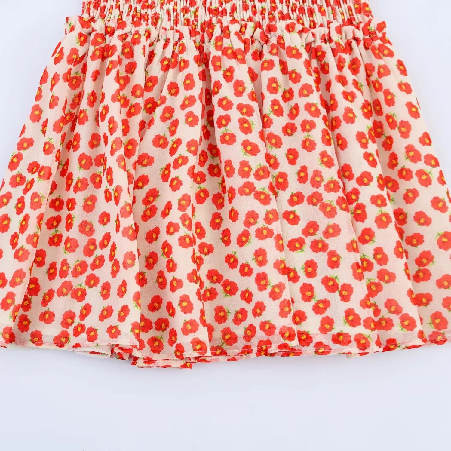 Close-up of the flared A-line skirt hem on the peach floral chiffon dress