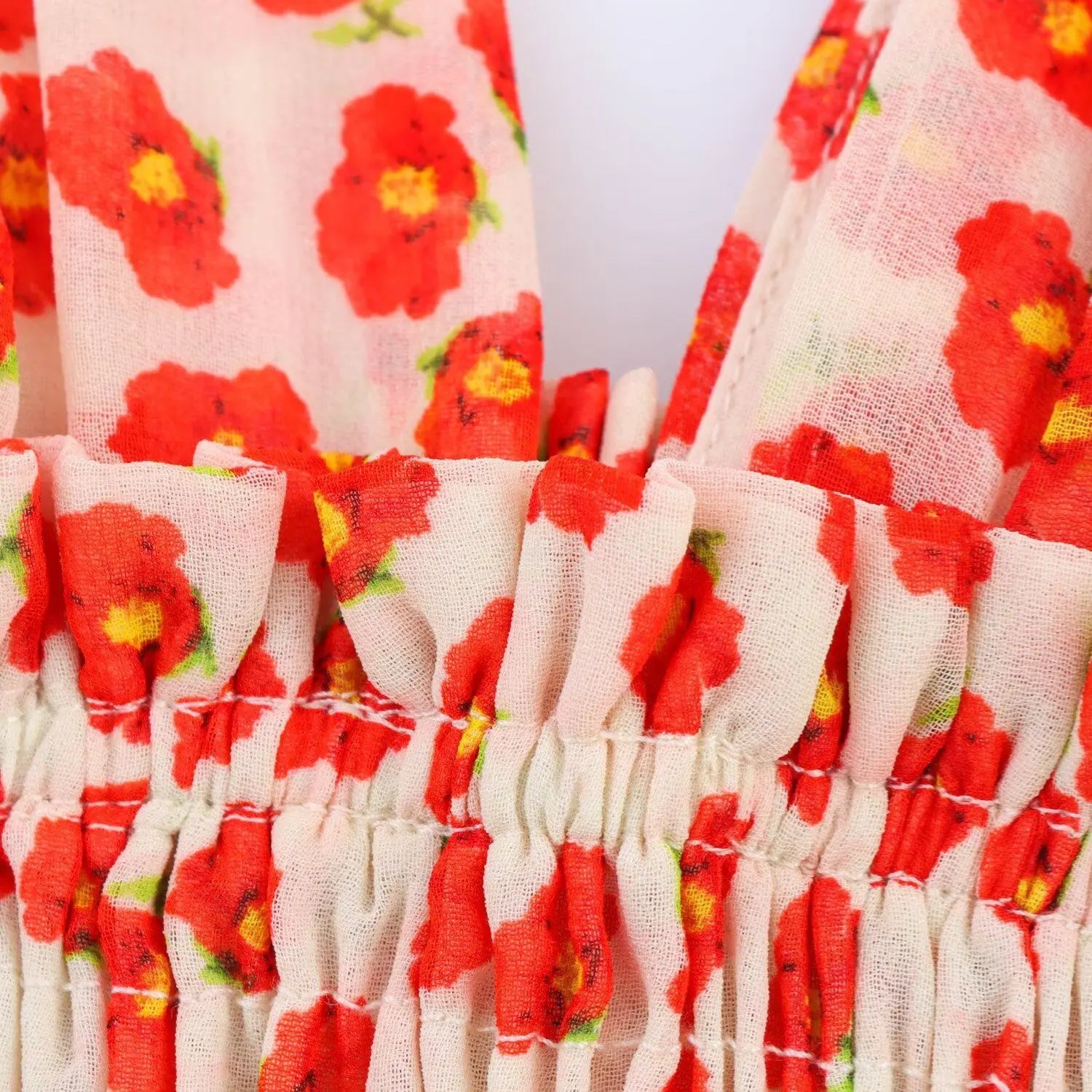 Close-up of the ruffled elastic waistband on the peach floral chiffon dress