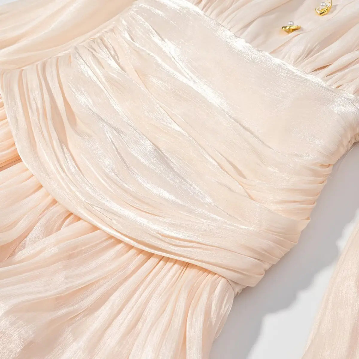 Waist detail of peach iridescent dress, showing the gathered fabric and sheen