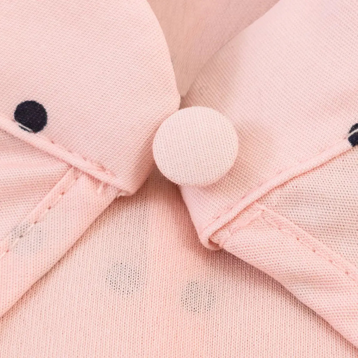 Close-up of the matching peach-colored button on the mandarin collar of the polka dot top