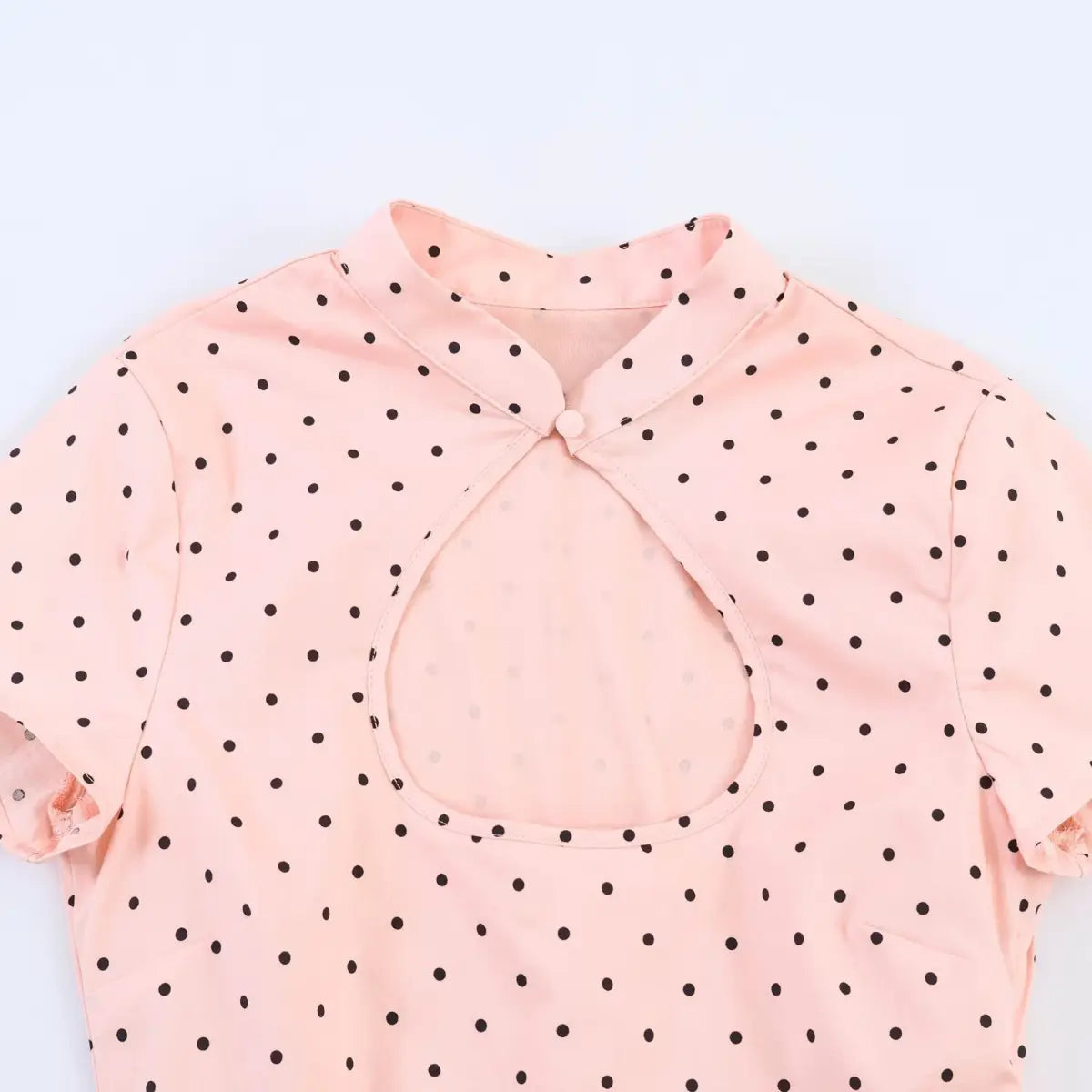 Front view of peach polka dot cheongsam-style top, showing the keyhole neckline, mandarin collar, and single top button