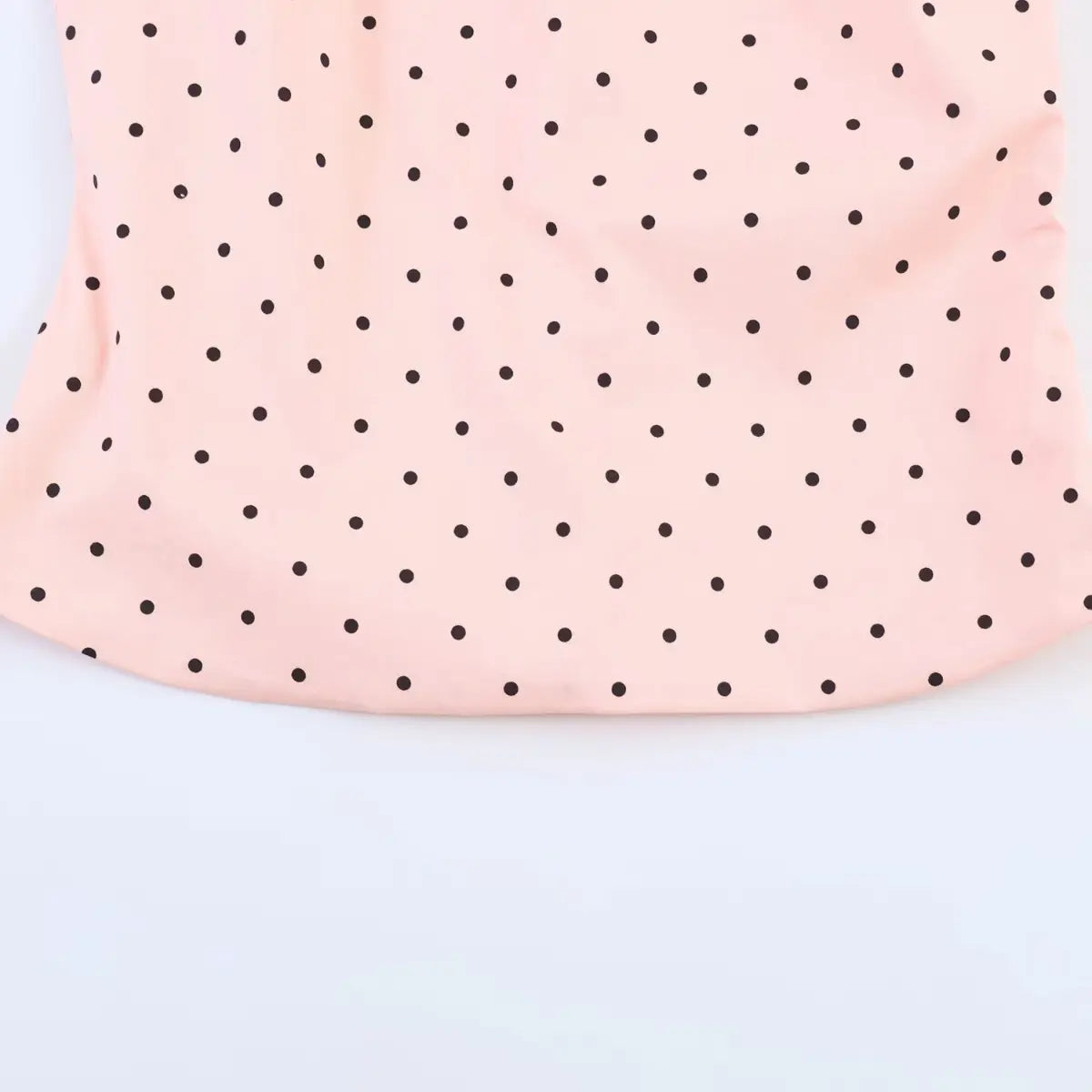 Hem detail of the peach polka dot top, showing the finished edge and even polka dot pattern