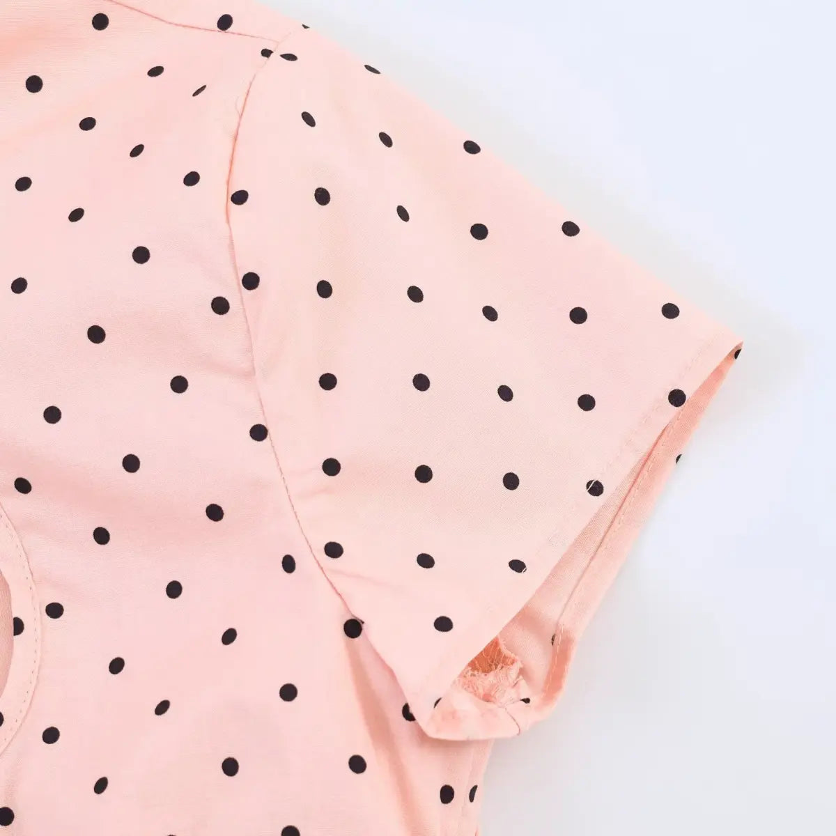 Sleeve cuff detail of the peach polka dot top, showing the finished edge and polka dot pattern