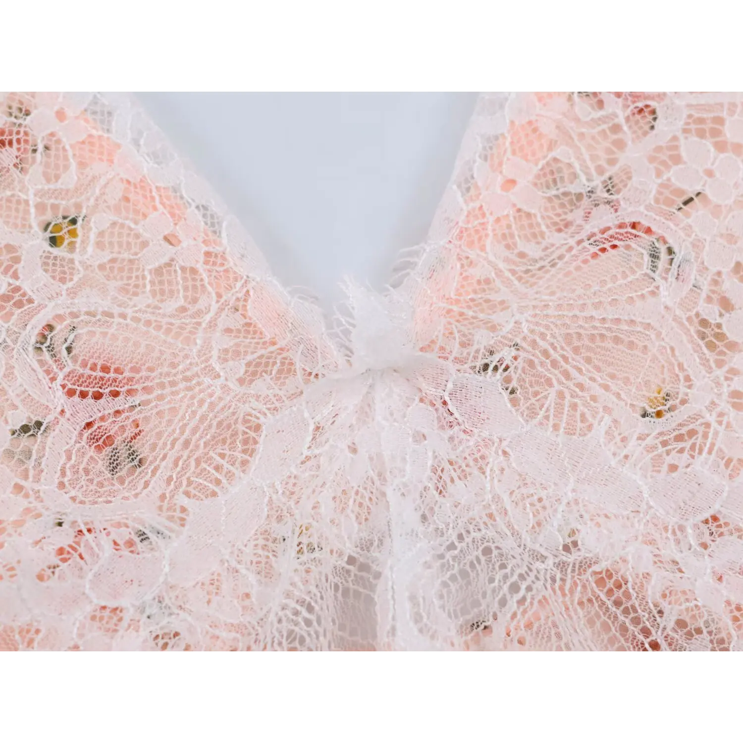 Extreme closeup front center lace twist knot at v neck, romantic lace construction