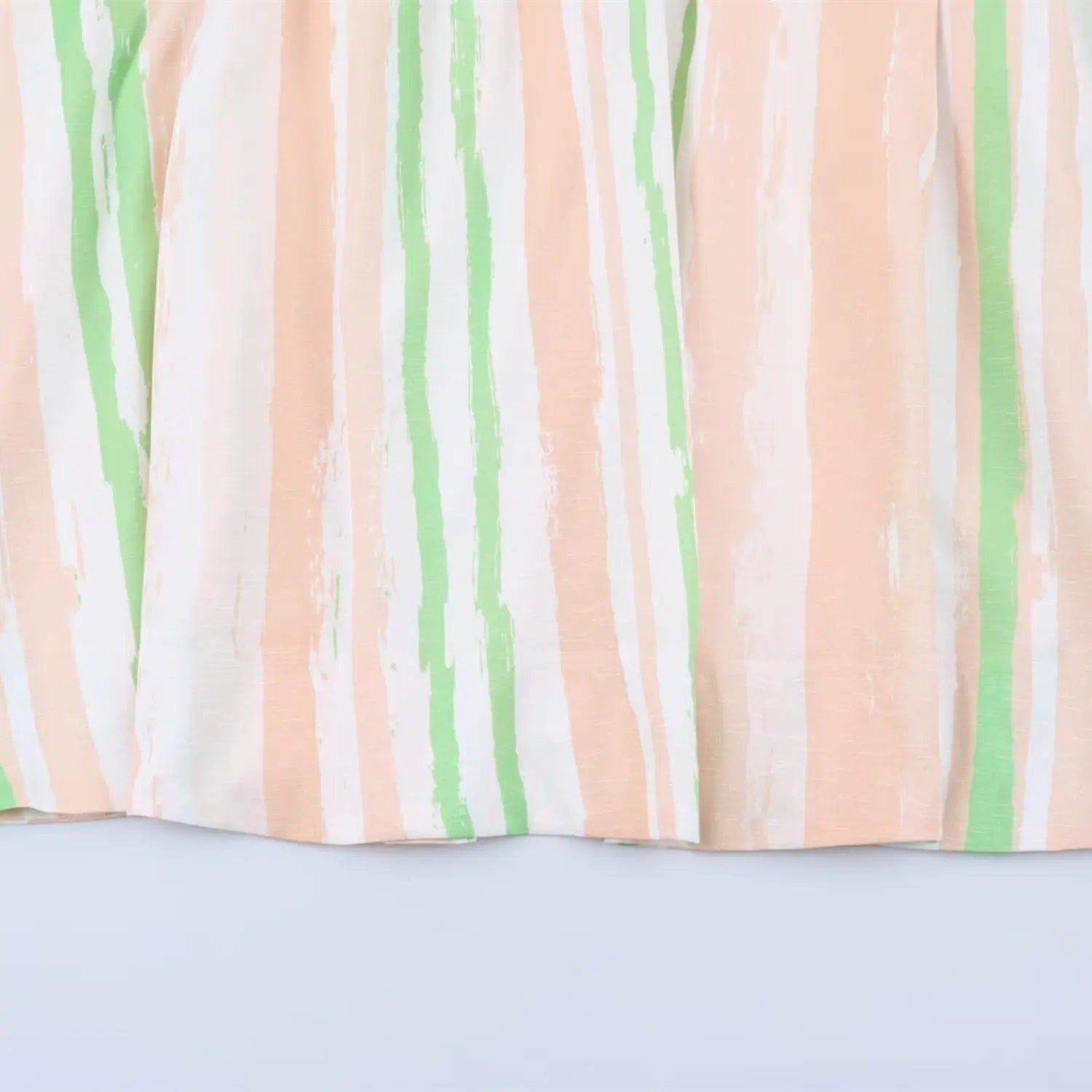 Close‑up of brush‑stroke stripe fabric print for peach green maxi dress