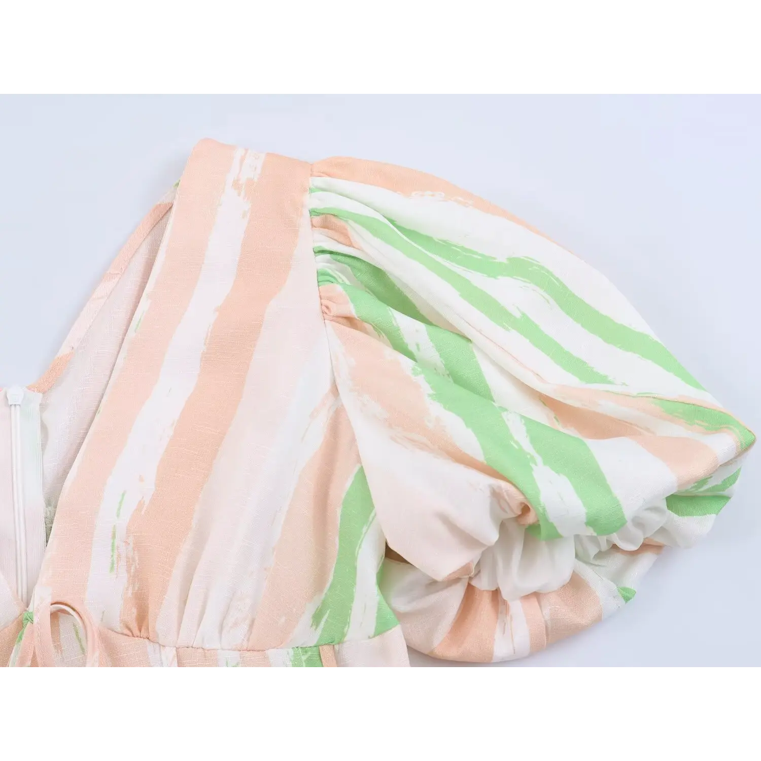 Detail shot of short puff sleeve on peach green stripe maxi dress