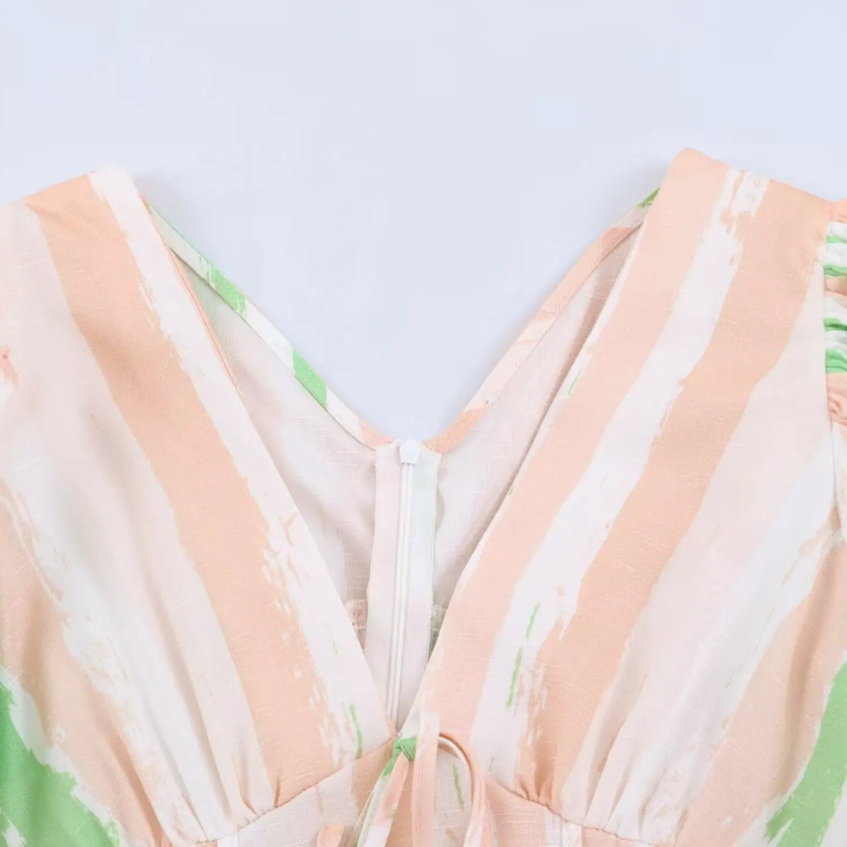 Close‑up view of v‑neck bust detail on peach green brush stripe maxi dress