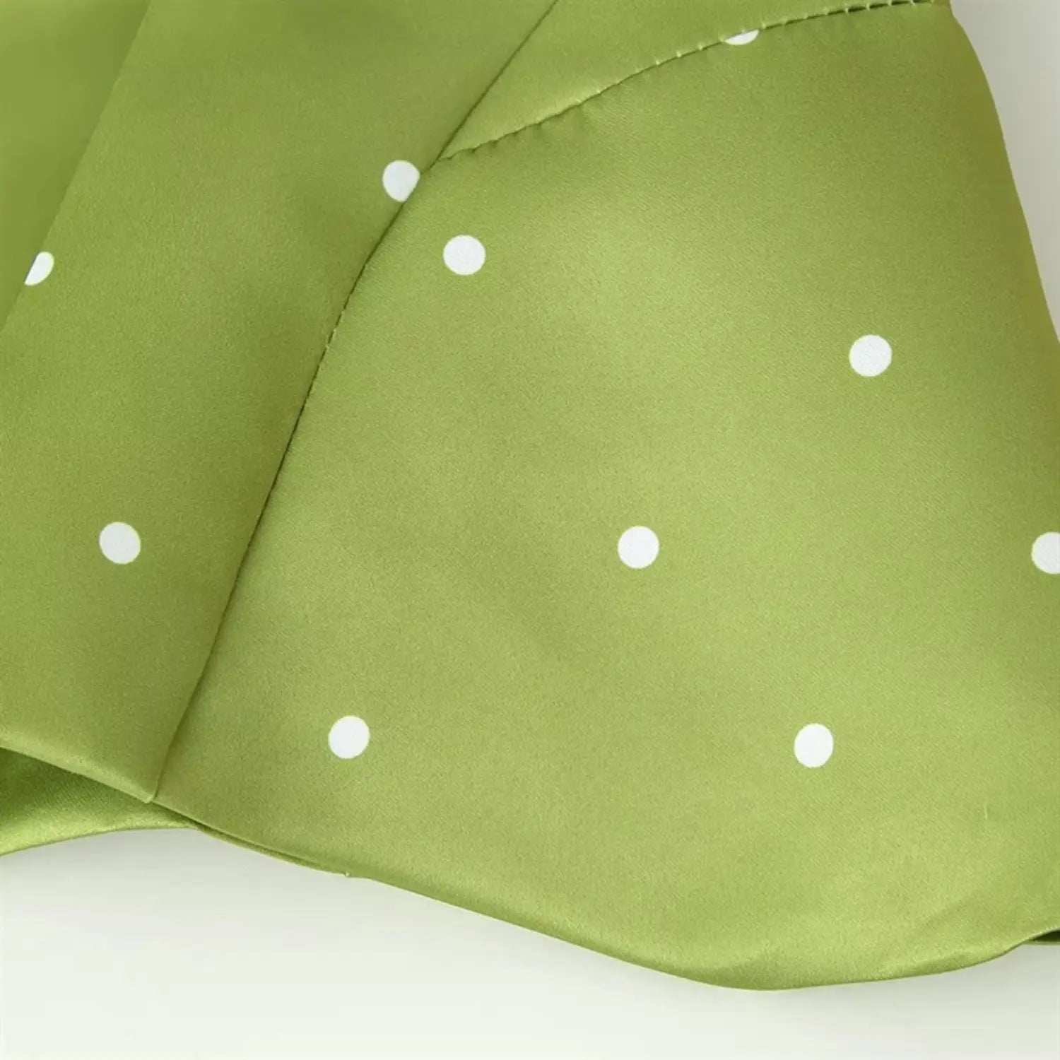 Partial shot of flared peplum hem, curved ruffled edge, natural fabric flow, waist-to-skirt transition seam