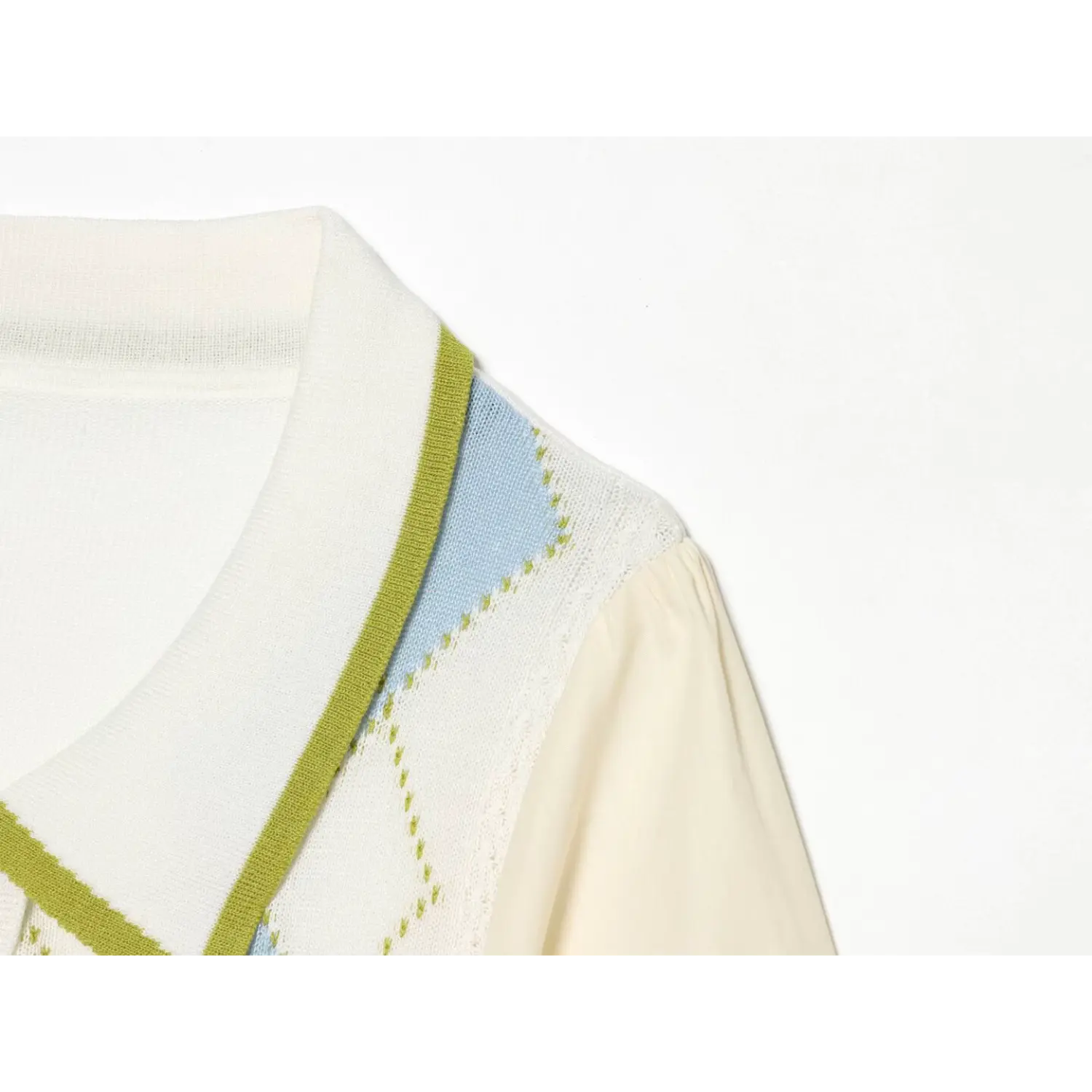 Shoulder neck partial shot contrast green piped peter pan collar, argyle knit front spliced to cream poplin puff sleeve, preppy color block detail