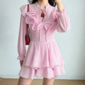 Model wearing light pink stand collar long sleeve mini dress with 3D floral appliques and double-layer ruffle skirt