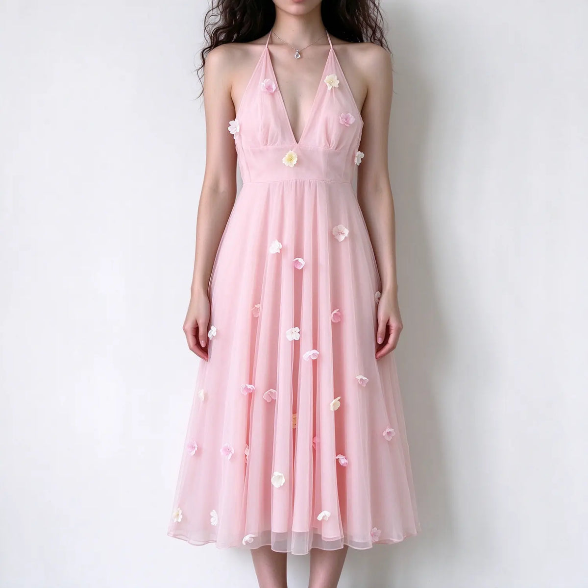 Model wearing pink halter maxi dress, deep v neck, tulle fabric decorated with 3d flower appliques, flowy long skirt, plain white background