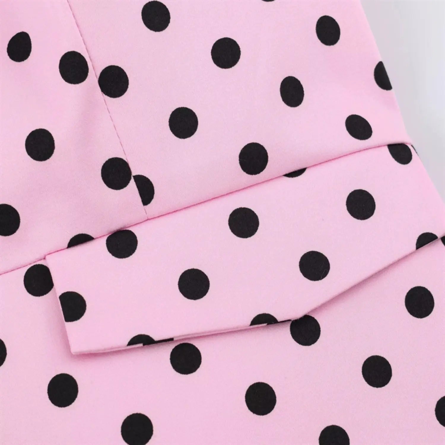 Pink base black circular polka dot fabric drape macro, clear dot printing, soft smooth woven suit fabric texture
