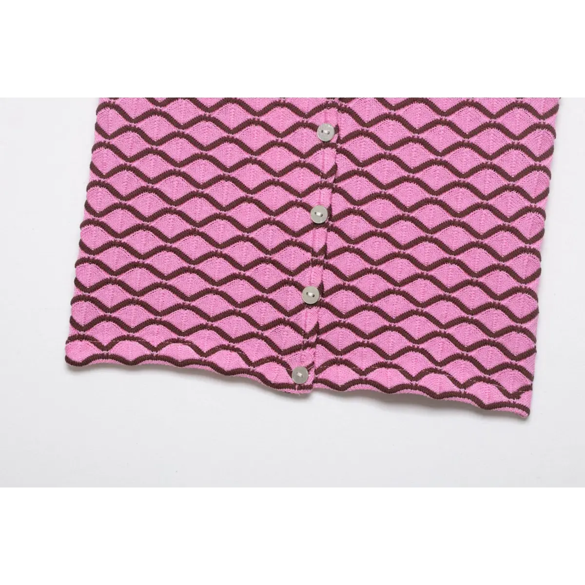 Bottom hem view of pink and brown geometric knit cardigan, showing the full pattern and button placket