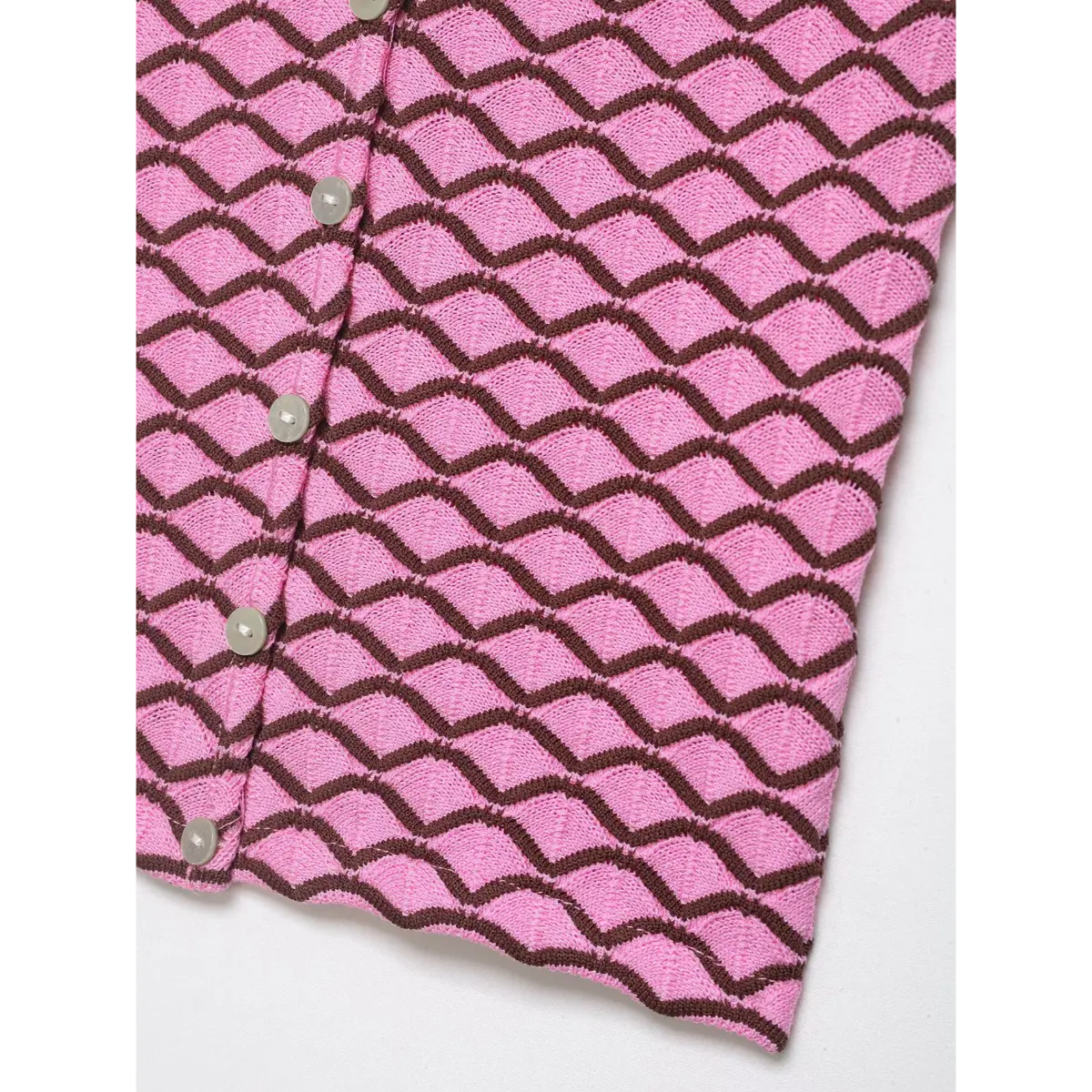 Corner view of pink and brown geometric knit cardigan, showing the pattern and button placket from an angle