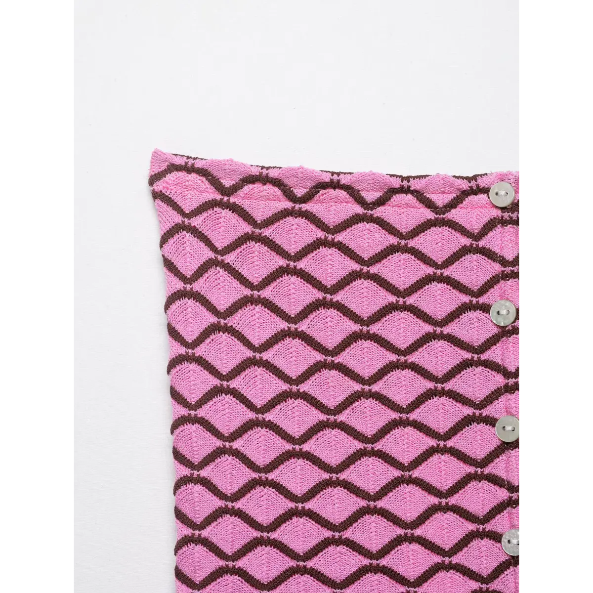 Top edge view of pink and brown geometric knit cardigan, showing the neckline and buttons