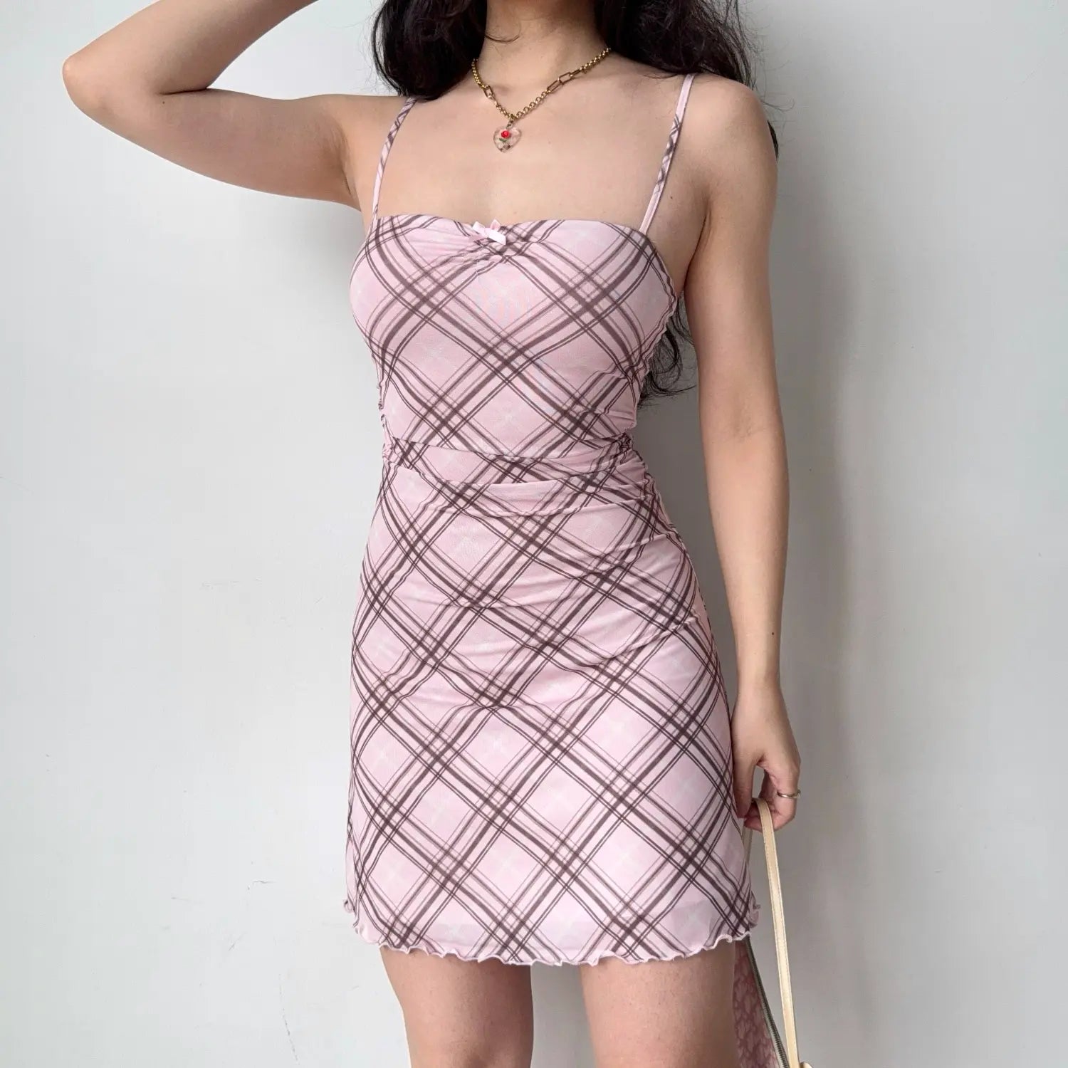Model front view shot, pink brown diagonal plaid mesh cami mini dress with tiny chest bow, waist ruched detail and wavy hem trim