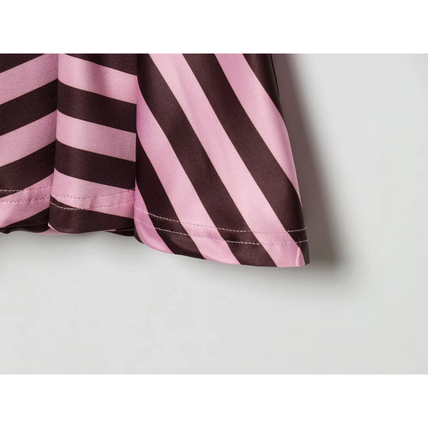 Hem edge macro, double line lockstitch finishing on flared ruffle, diagonal stripe fabric bias cut for soft flare drape