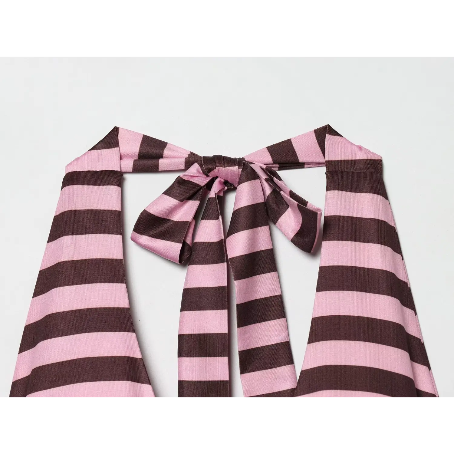  Three-quarter close-up of back halter bow, thick stretch satin stripe fabric, full fabric streamers for length adjustment, clean folded neck binding