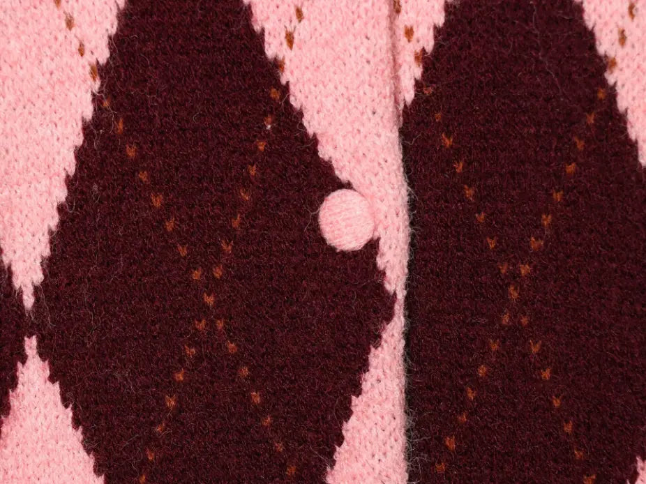 Macro close-up of pink knit button and argyle pattern
