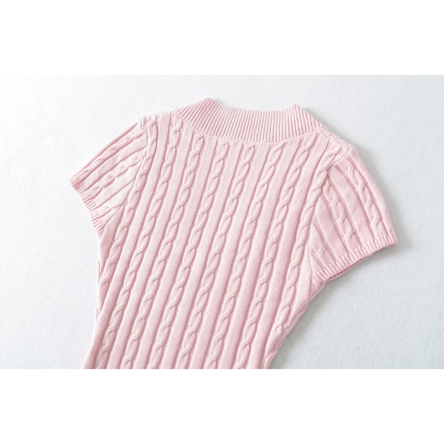 Close‑up back shoulder view showing cable knit pattern of pink fitted knit top